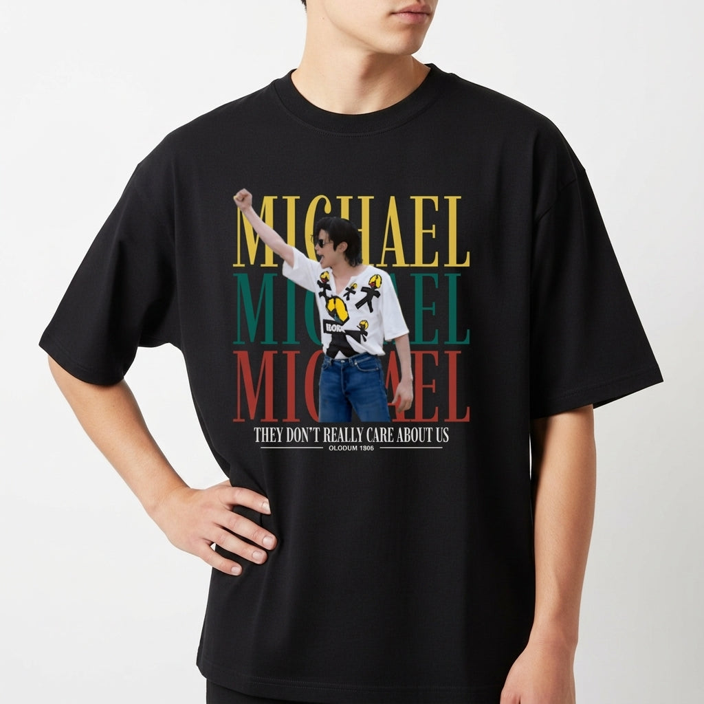 Camiseta com estampa frontal de um artista performando, sobreposta a três repetições do nome "Michael" em amarelo, verde e vermelho, acompanhada da frase "They Don't Really Care About Us".