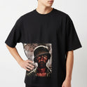 Camiseta com estampa frontal de soldado em cena de guerra envolvendo tanques e figura usando capacete militar, com expressão intensa sob céu dramático.