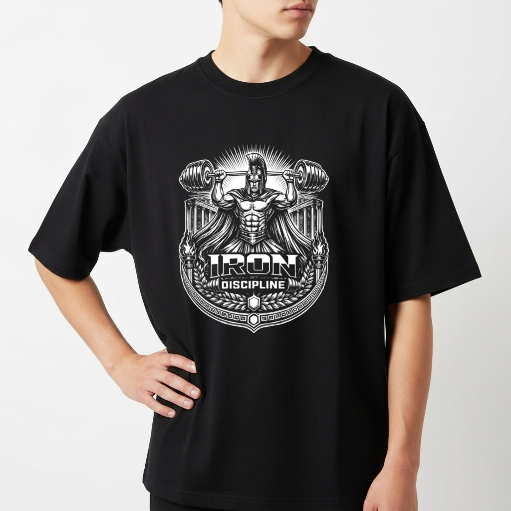 Camiseta com estampa frontal de figura mitológica levantando halteres grandes, rodeada por padrões ornamentais e texto "Iron Discipline" em destaque.
