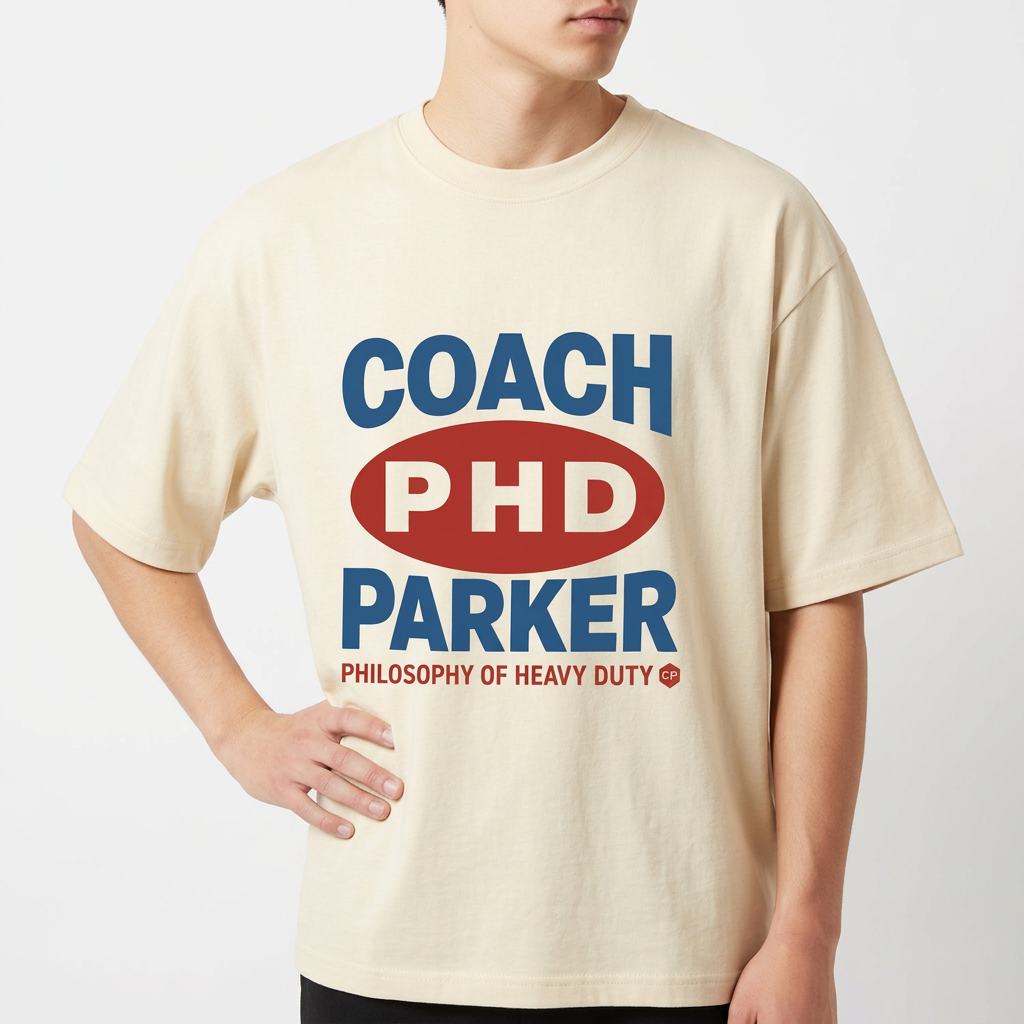 Camiseta com estampa frontal de texto em destaque centralizado, incluindo letras maiúsculas "COACH PHD PARKER" e frase complementar na parte inferior.