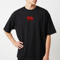 Camiseta com estampa frontal de letras estilizadas "No Mercy Club" com efeito escorrido e estampa traseira de uma cobra com capuz erguido e detalhes geométricos.