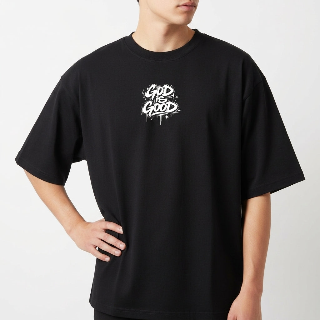 Camiseta com estampa frontal de lettering estilizado "God is Good" e estampa traseira de ilustração de anjo com a palavra "Justice" e detalhes de texto.