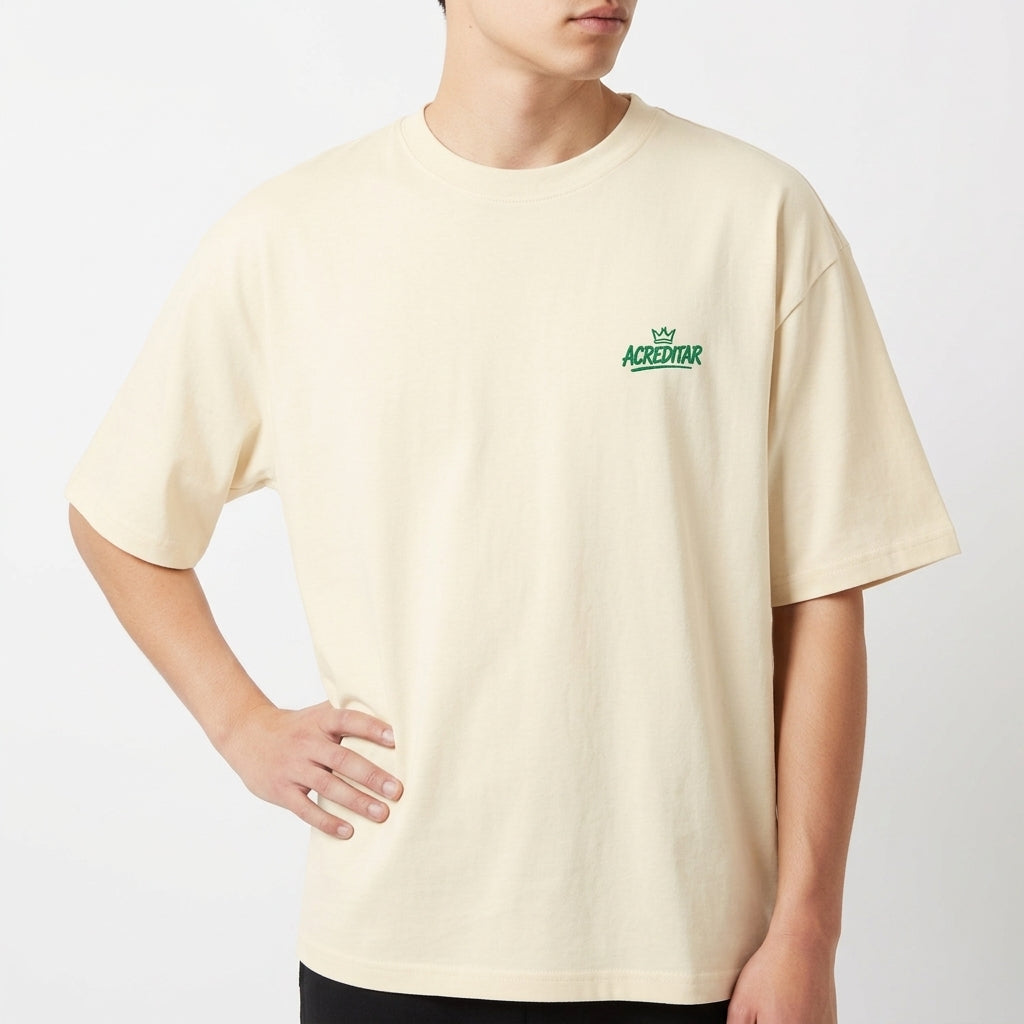 Camiseta com estampa frontal de pequena coroa e "ACREDITAR" estilizado, e estampa traseira de jogador com coroa, cores vibrantes e mensagem inspiradora.