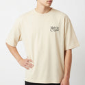 Camiseta com estampa frontal de "Made by Creator" em letras estilizadas e estampa traseira de "Made by Creator" acompanhada por ilustração de flores coloridas.