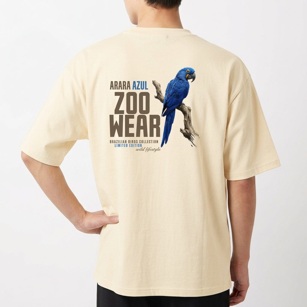 Camiseta com estampa frontal de arara azul em postura lateral com texto circular pequeno e estampa traseira de arara azul maior com texto "ZOOWEAR".