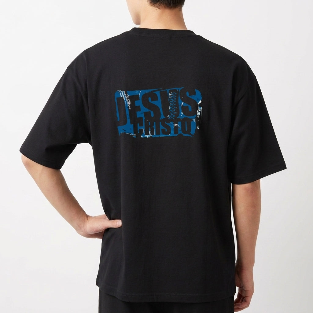 Camiseta com estampa frontal de "Jesus Cristo" em efeito desgastado e estampa traseira ampliada do mesmo motivo com visual rústico.