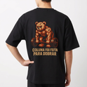 Camiseta com estampa frontal de letras estilizadas em destaque e estampa traseira de urso musculoso levantando peso, acompanhada pela frase motivacional.