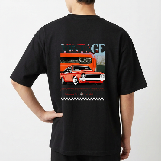 Camiseta com estampa traseira de carro vintage estilizado, com destaque para faróis e grade frontal, acompanhada da palavra "VINTAGE" e padrão quadriculado.