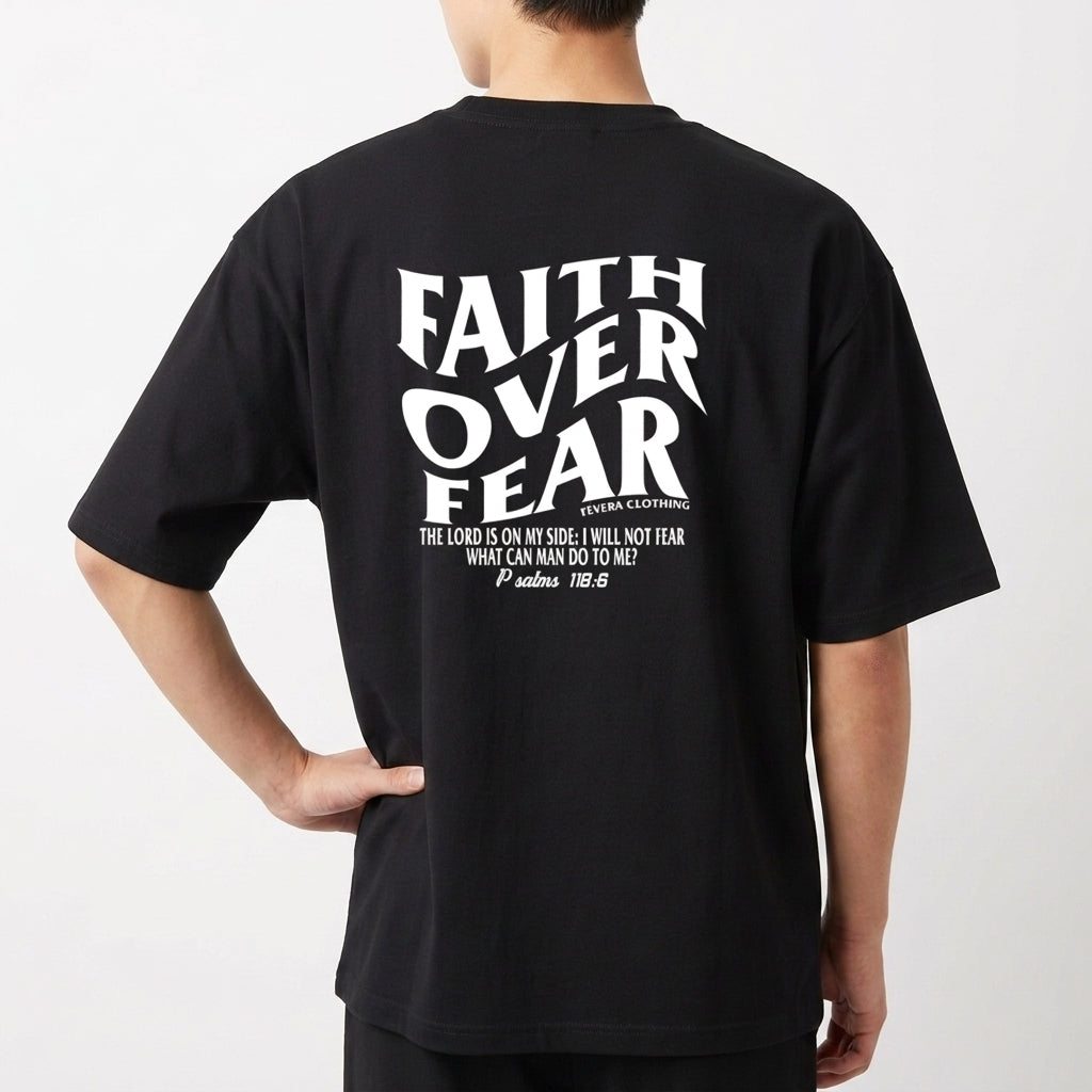 Camiseta com estampa frontal de "Faith Over Fear" com detalhes em texto pequeno e estampa traseira de "Faith Over Fear" acompanhada de citação extensa.