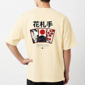 Camiseta com estampa frontal de escrita estilizada "Haganne" e estampa traseira com cartões de Hanafuda, garça, montanha e grafismos japoneses.