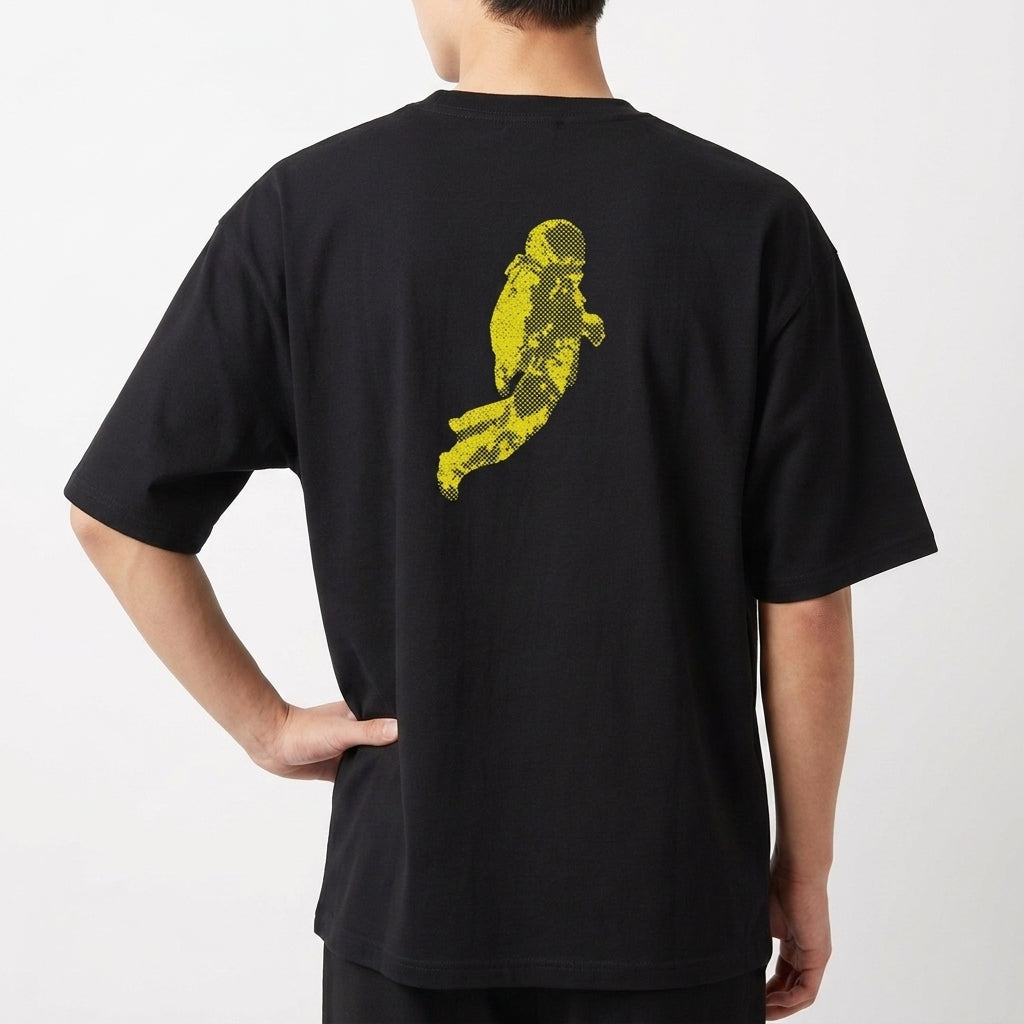 Camiseta com estampa frontal de texto estilizado e estampa traseira de astronauta em forma pixelada.