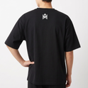Camiseta com estampa frontal de rosto sorridente decorado com folhas e texto "Elevate Your Frequency" emoldurado por elementos naturais e estampa traseira de símbolo geométrico simples próximo à gola.