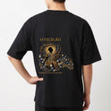 Camiseta com estampa frontal de design intrincado com elementos florais ao redor de texto e estampa traseira de figura mística centralizada com ornamentos detalhados.