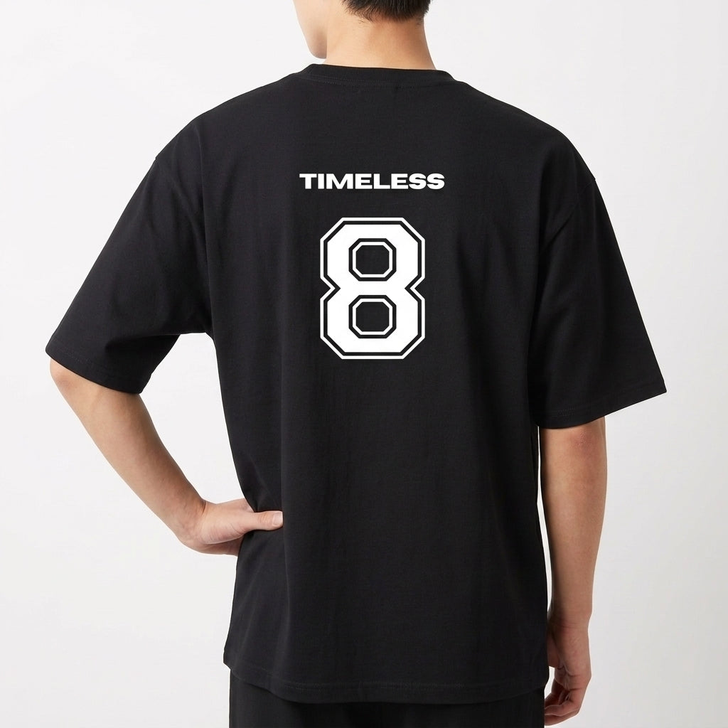 Camiseta com estampa frontal de dois brilhos estilizados e estampa traseira de um número "8" grande, acompanhado da palavra "TIMELESS" acima.