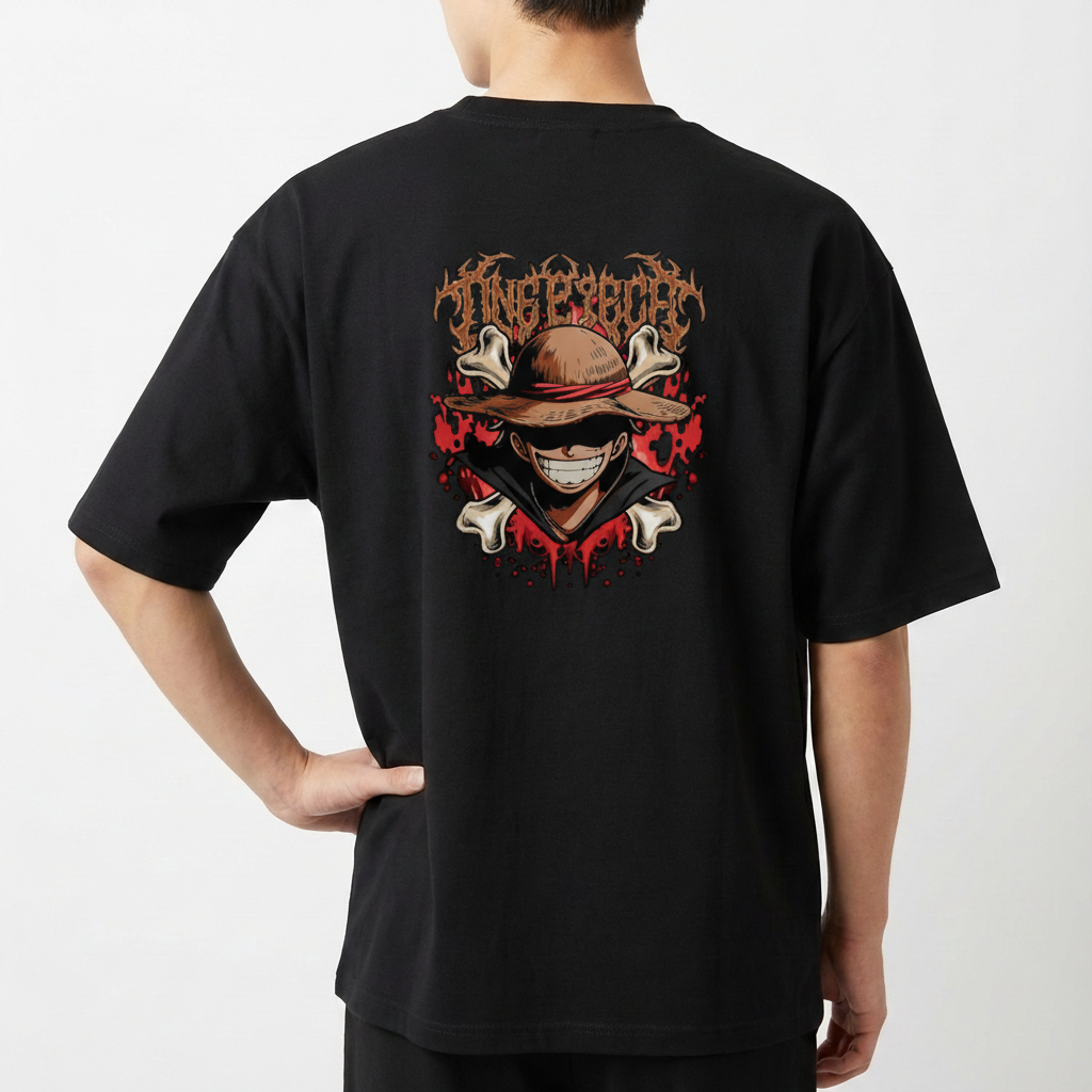 Camiseta com estampa frontal de personagem sorridente usando chapéu e estampa traseira de crânio estilizado cercado por ossos, malhas e texto gótico.