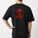 Camiseta com estampa frontal de letras estilizadas "No Mercy Club" com efeito escorrido e estampa traseira de uma cobra com capuz erguido e detalhes geométricos.