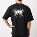 Camiseta com estampa frontal de texto estilizado "Pântano 3000" em um design de respingos e estampa traseira com padrão abstracto intrincado com elementos pontiagudos.