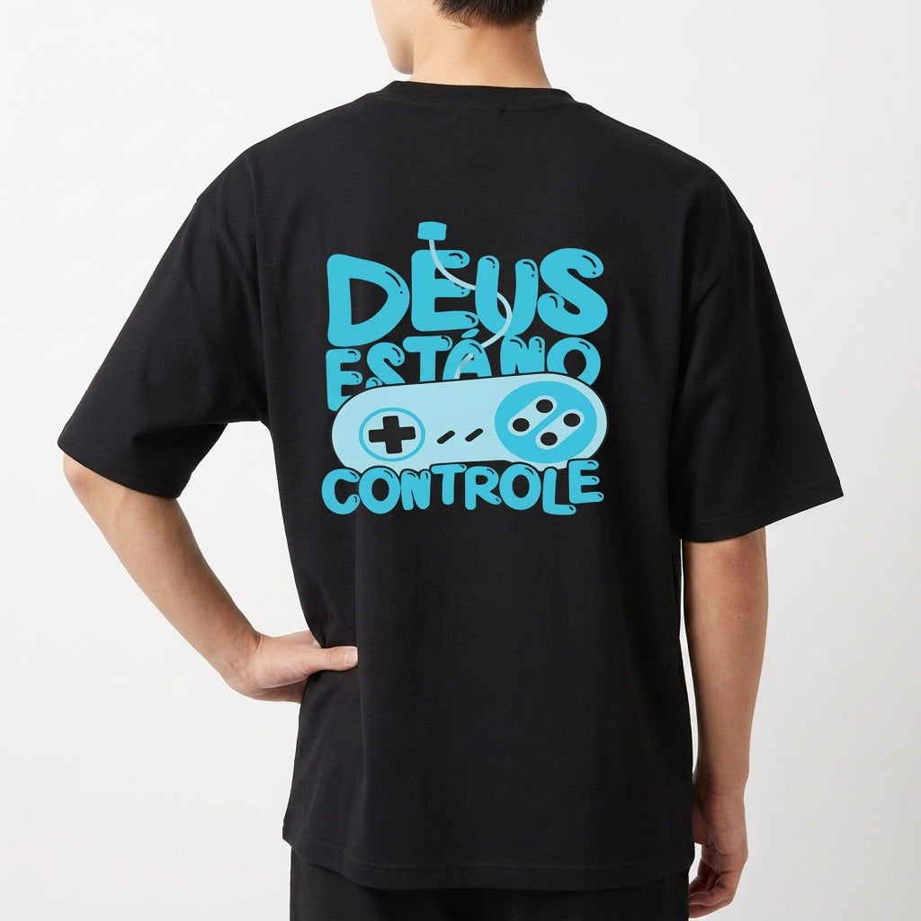 Camiseta com estampa frontal de logo pequeno escrito “VIGIA” no centro e estampa traseira de controle de videogame com frase “DEUS ESTÁ NO CONTROLE”.