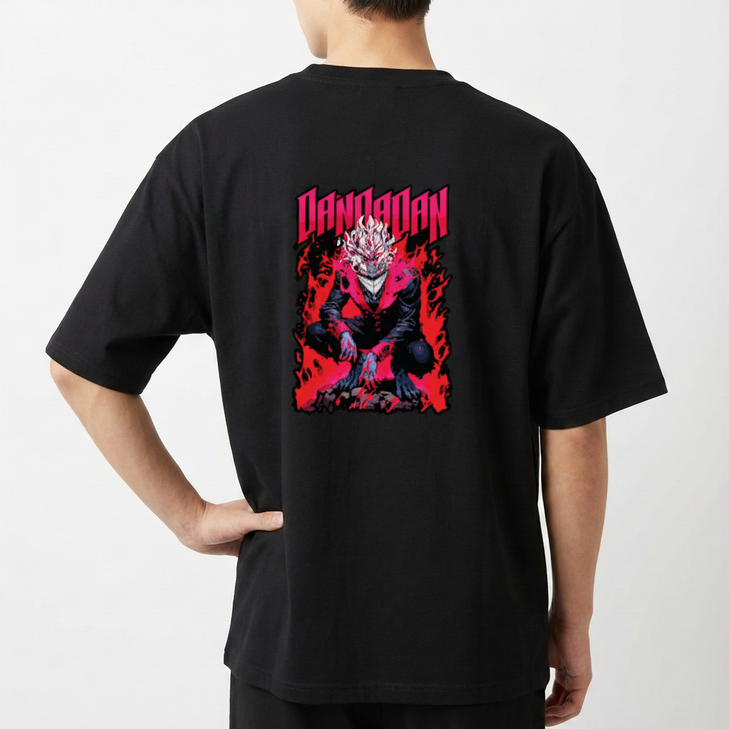 Camiseta com estampa frontal de pequeno dragão estilizado e estampa traseira de dragão humanoide agachado em meio a chamas e texto "DANDADAN".