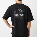Camiseta com estampa frontal de beija-flor em voo e estampa traseira com beija-flor em destaque, acompanhada de elementos gráficos e texto estilizado.
