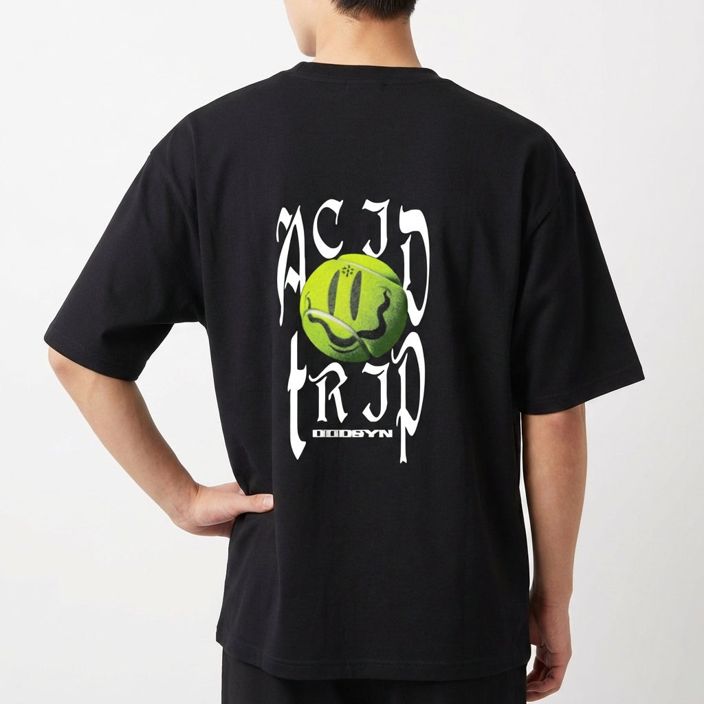 Camiseta com estampa frontal de texto estilizado. Estampa traseira de bola sorridente verde com textos verticais distorcidos e estilizados ao redor.