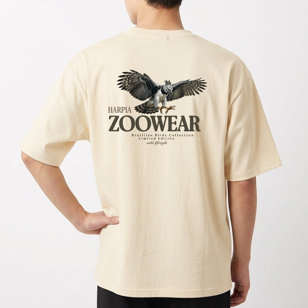 Camiseta com estampa frontal de águia detalhada, cercada por texto em círculo; e estampa traseira semelhante com águia maior, texto "Zoowear" e descrição adicional.