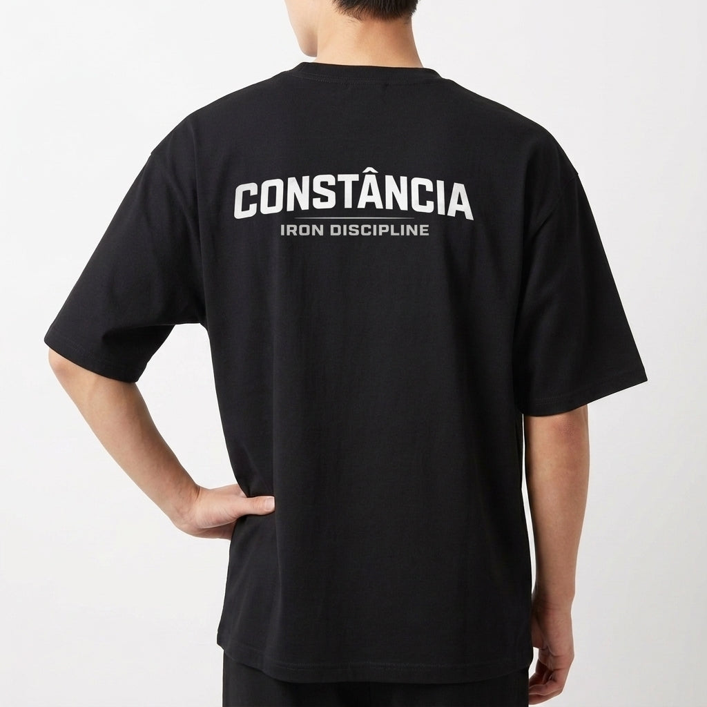 Camiseta com estampa frontal de "IRON DISCIPLINE" com design gráfico e estampa traseira de "CONSTÂNCIA IRON DISCIPLINE" em fonte destacada e marcante.