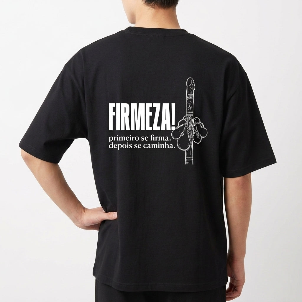 Camiseta com estampa frontal de duas chaves cruzadas detalhadas, e estampa traseira de uma mão levantada ao lado da frase "FIRMEZA! primeiro se firma, depois se caminha.".