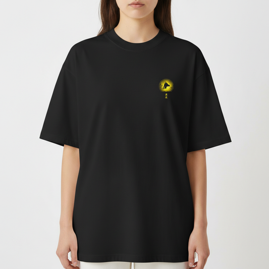 Camiseta com estampa frontal de símbolo circular com silhueta e estampa traseira de figura dinâmica em frente a um disco grande e um busto pequeno.