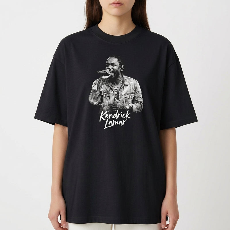 Camiseta com estampa frontal de um cantor segurando um microfone, exibindo detalhes de uma jaqueta e um nome logo abaixo em fonte estilizada.
