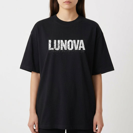 Camiseta com estampa frontal de "LUNOVA" em letras grandes e efeito desgastado, e estampa traseira de um olho detalhado entre "OPEN YOUR EYES".