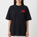 Camiseta com estampa frontal de texto estilizado em caixa vermelha e estampa traseira de retrato vintage com linhas verticais e texto cruzado.