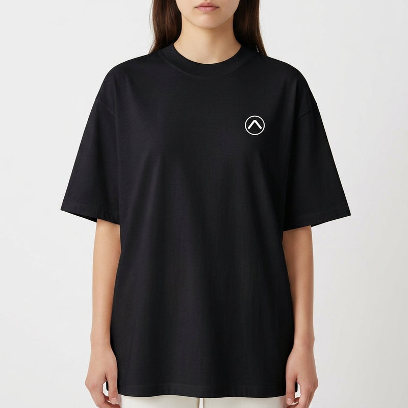 Camiseta com estampa frontal de pequeno símbolo circular com seta apontando para cima no lado esquerdo do peito e estampa traseira de surfista em túnel de onda dinâmica com efeitos de pinceladas.