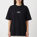 Camiseta com estampa frontal de texto cursivo "Verbo" e estampa traseira de coroa, montanhas, estrela e frases expressivas em texto impactante.