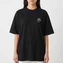 Camiseta com estampa frontal de símbolo geométrico simples no peito e estampa traseira de skatista em ação com efeito gráfico de tinta em respingos.