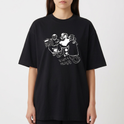 Camiseta com estampa frontal de dois personagens sentados com um dispositivo, um dos personagens sorridente e mãos aos ombros, e estampa traseira de gaiola minimalista com texto pequeno.