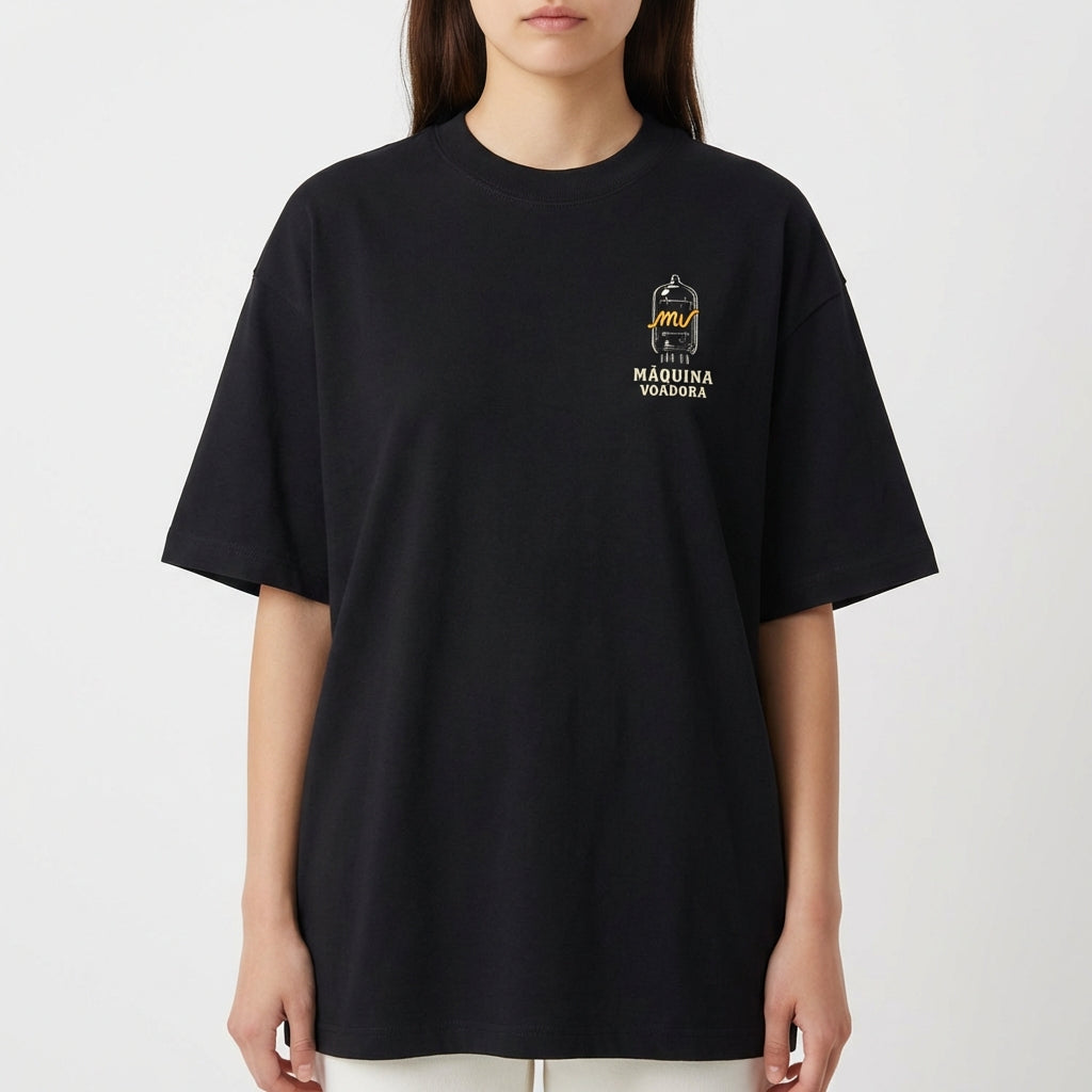 Camiseta com estampa frontal de desenho de um passarinho dentro de uma gaiola estilizada com a inscrição "Máquina Voadora" abaixo do desenho.