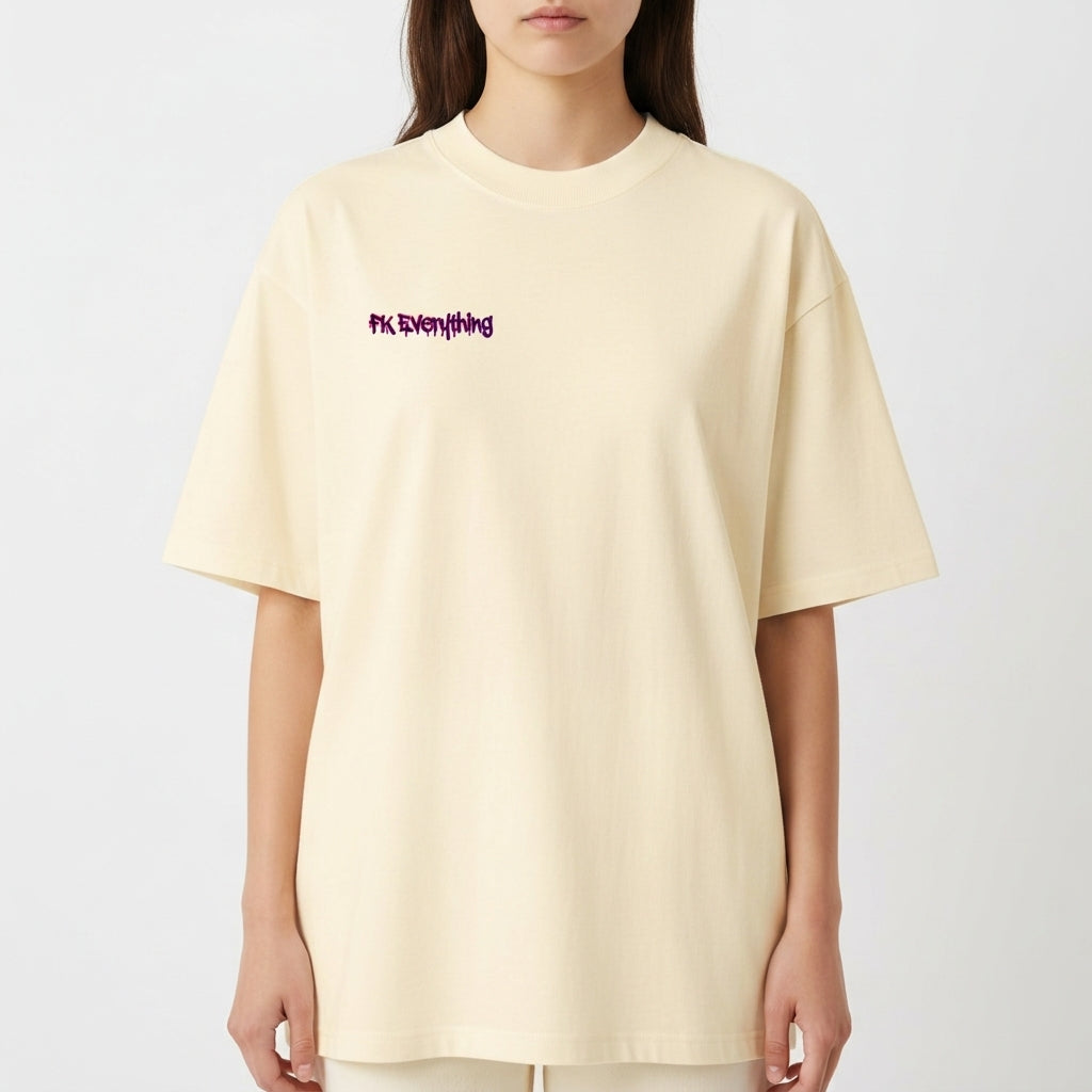 Camiseta com estampa frontal de frase estilizada e estampa traseira de urso com olhos em cruz, fundo de tinta respingada e símbolos de flechas e ferramentas.