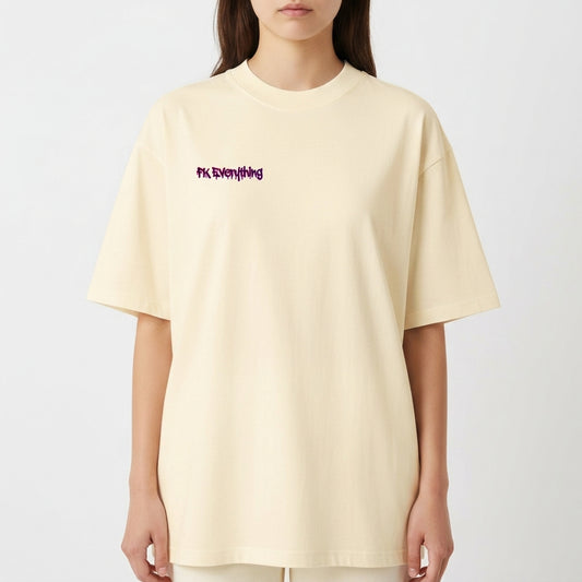 Camiseta com estampa frontal de frase estilizada e estampa traseira de urso com olhos em cruz, fundo de tinta respingada e símbolos de flechas e ferramentas.
