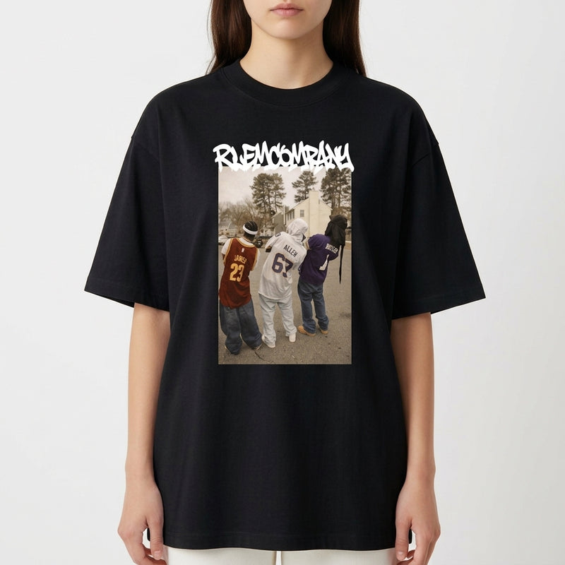 Camiseta com estampa frontal de três pessoas de costas usando camisetas de basquete, em frente a uma rua com árvores, sob um texto estilizado na parte superior.