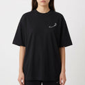 Camiseta com estampa frontal de assinatura estilizada delicada e estampa traseira de dragão tribal detalhado com asas curvas e cauda serpenteante.