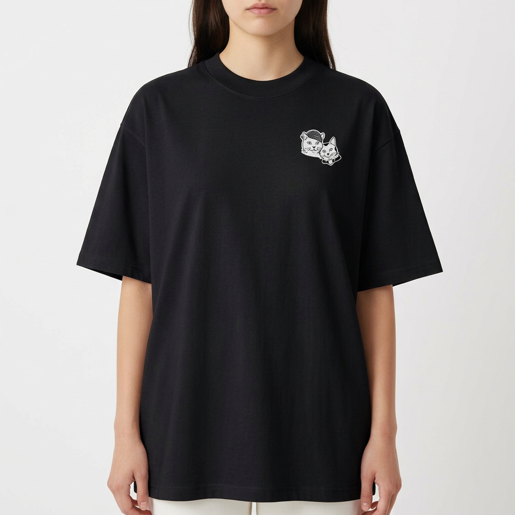Camiseta com estampa frontal de duas cabeças de gatos em estilo ilustrativo e estampa traseira de dois gatos sentados rodeados por detalhes artísticos.