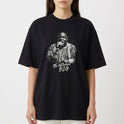 Camiseta com estampa frontal de um artista segurando um microfone e trajando roupa detalhada, acompanhada da inscrição estilizada "The Notorious B.I.G.".