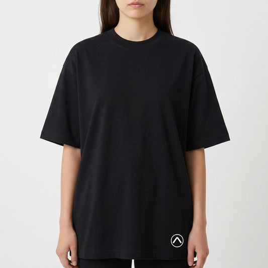 Camiseta com estampa frontal de símbolo minimalista no canto inferior e estampa traseira de paisagem praiana ao entardecer com padrão de calçada ondulada.