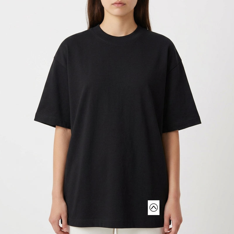Camiseta com estampa frontal de pequeno logotipo minimalista e estampa traseira de folhas tropicais em diversas cores e círculo texturizado.