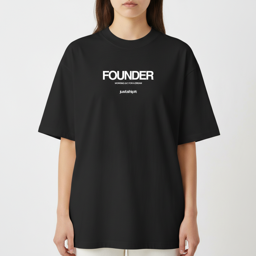 Camiseta com estampa frontal de texto em três partes: "FOUNDER" no topo, "WORKING 24/7 FOR A DREAM" no centro e "justshipit" na base.