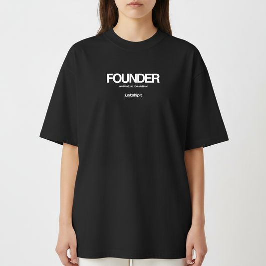 Camiseta com estampa frontal de texto em três partes: "FOUNDER" no topo, "WORKING 24/7 FOR A DREAM" no centro e "justshipit" na base.