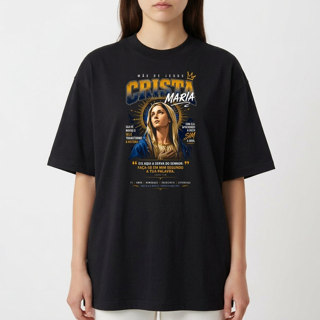 Camiseta com estampa frontal da imagem de Maria com coroa e auréola, cercada por texto estilizado, destacando frases e pequenas ilustrações gráficas.