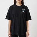 Camiseta com estampa frontal de “L5 2C” em estilo pixelizado e texto menor em roxo, e estampa traseira ampliada do mesmo texto com caracteres adicionais.