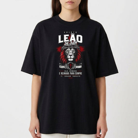 Camiseta com estampa frontal de um leão acompanhado de texto "Cristo Leão de Judá", escudo e datas, destacando simbolismo religioso e força.